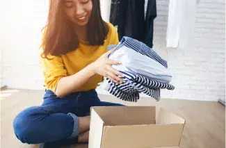 Une jeune femme qui range des vêtements