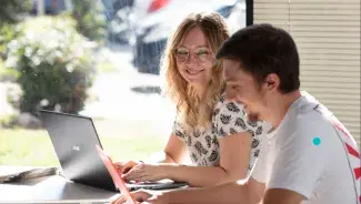 Deux personnes devant un ordinateur portable