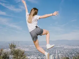 Une jeune femme de dos qui saute en l'air