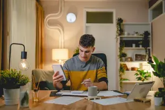 Etudiant calculant les aides financières en résidence étudiante