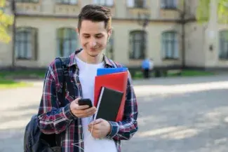 Closeup photo portrait of cheerful positive delightful nice handsome glad millennial choosing song on his mp3 player